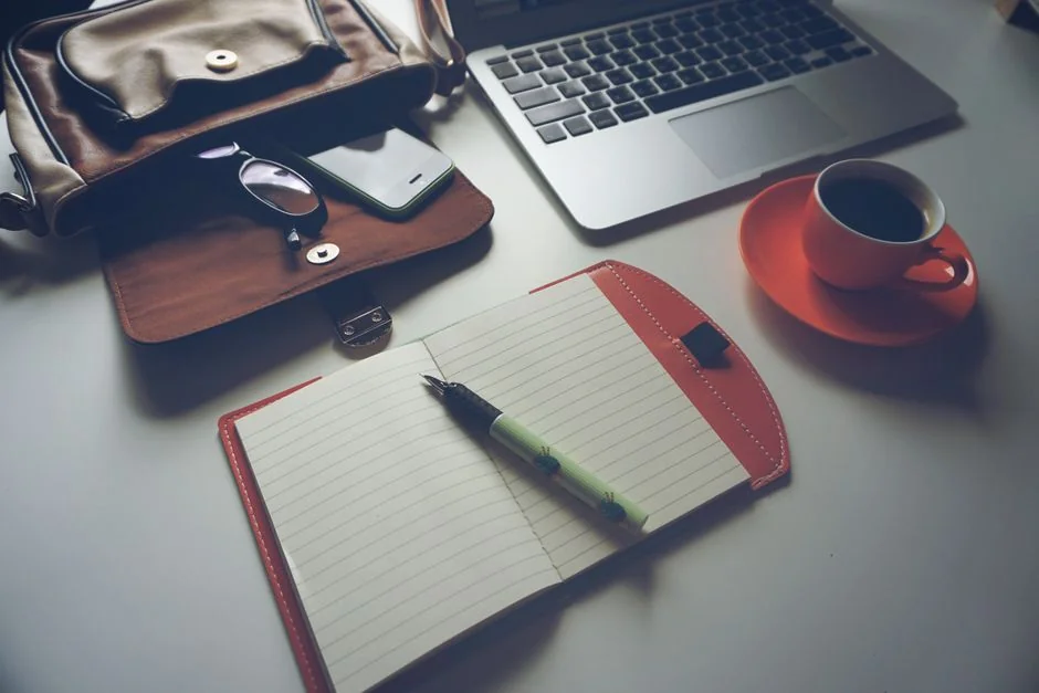 Primer plano de una laptop con un sitio web de comercio electrónico abierto, rodeada de una decoración de oficina moderna.