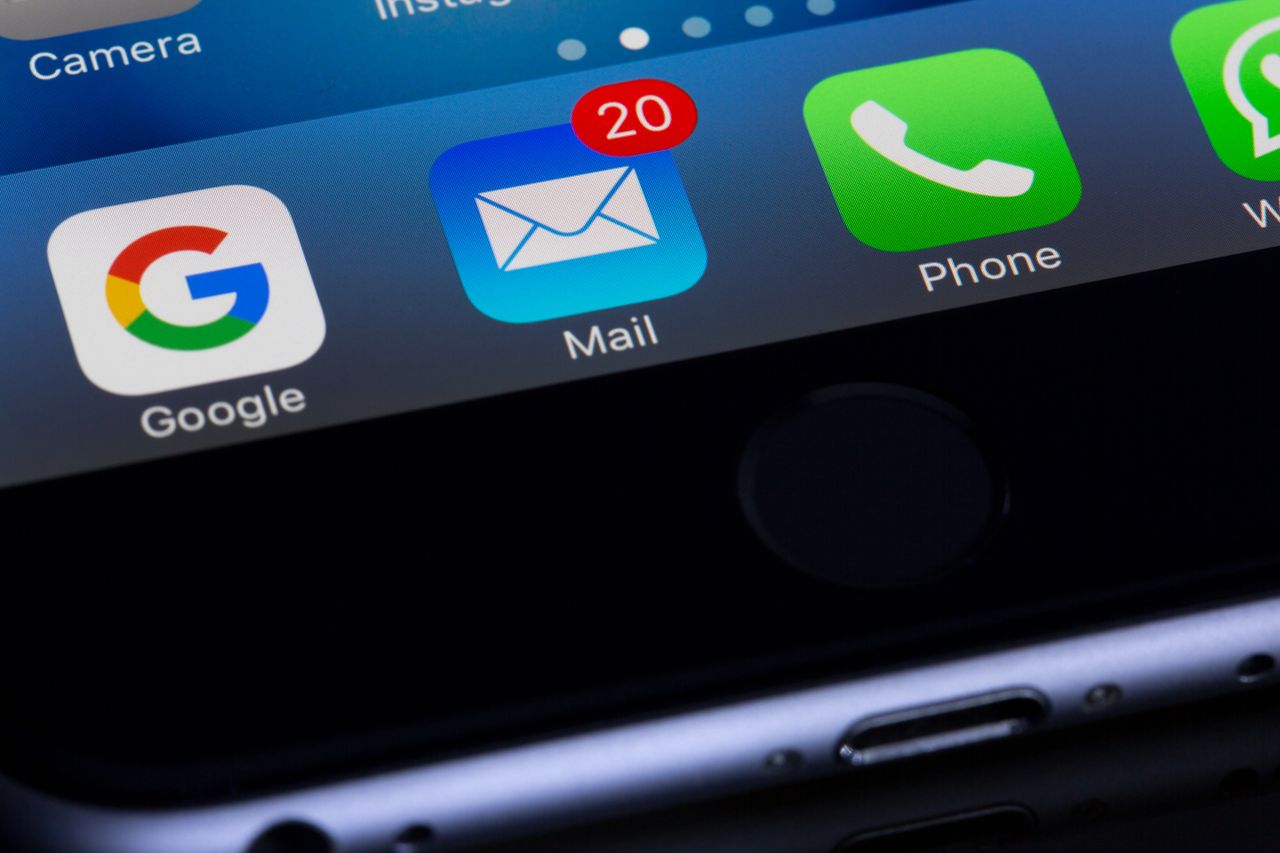 A close-up image of a smartphone showing well-known apps such as Google and Mail.